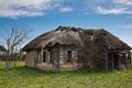 Abandoned Russian village. Ruins of rural house with thatched roof