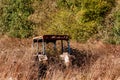 Abandoned rusting tractor in hedge row