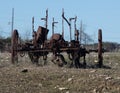 Abandoned, rusting vintage farm equipment in an open field