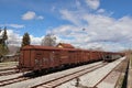 Abandoned rusty brown train wagons on a railway under a blue sky with clouds, Amyntaio, Greece Royalty Free Stock Photo