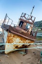 An abandoned rusty ship on a sandy beach