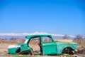 Abandoned wreck of an old green Soviet Russian car in the middle of dry agricultural land in Southern Armenia