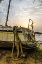 Abandoned sailing boat or yacht laying on beach in Kribi, Cameroon during sunset, Africa