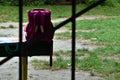 Abandoned school backpack on the edge of the bench Royalty Free Stock Photo
