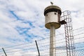 Abandoned sentry box tower isolated by a net with barbed wire. Royalty Free Stock Photo