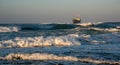 Abandoned ship in the stormy sea with big wind waves at sunset. Shipwreck in the ocean