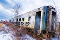 Abandoned, silver passenger train car in snow field under threatening deep blue winter sky. Royalty Free Stock Photo