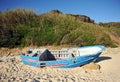 Abandoned small wooden boat -patera- on a beach near Tarifa, coast of Andalusia, Spain.