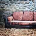 Abandoned sofa on side of building