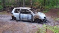 Abandoned stolen burnt out car near forest wood Royalty Free Stock Photo