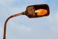 Abandoned street light, rusty metal post with lamp holder against blue sky background Royalty Free Stock Photo