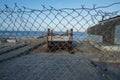 An abandoned structure tucked away behind a chain link fence.