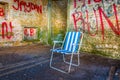 abandoned summer chair inside of an empty room decorated by various graphitti in gibraltar...IMAGE