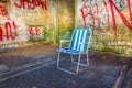 abandoned summer chair inside of an empty room decorated by various graphitti in gibraltar...IMAGE