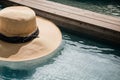 An abandoned sun hat floating in a calm pool