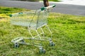 Abandoned supermarket shopping cart trolley on a green grass