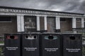 An abandoned toilet block, decaying with age, with four recycling bins in the foreground, also in poor condition, Royalty Free Stock Photo