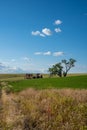 Abandoned tractor and farming equipment in an open field near a large tree in The Palouse region of Eastern Washington State Royalty Free Stock Photo