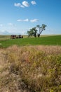 Abandoned tractor and farming equipment in an open field near a large tree in The Palouse region of Eastern Washington State Royalty Free Stock Photo