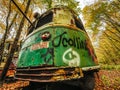 Abandoned Trolley Car in Woods in Fall with Caution Sign