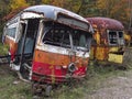 Abandoned trolley cars side on view with broken windows