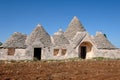 Abandoned Trulli house with multiple conical roofs located in a field in the area of Cisternino / Alberobello in Puglia, Italy