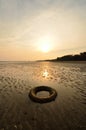 Abandoned tyre on the beach when the sun goes down