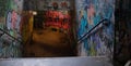 Abandoned underground passageway with old graffiti and old postcards on the walls