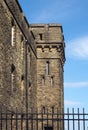 An abandoned victorian british stone institutional building surrounded by a fence typical of 19th century military and prison