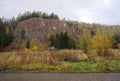 Abandoned village church, against the background of the autumn forest on a cloudy day.