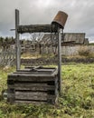 Old wooden well with an inverted bucket on a chain Royalty Free Stock Photo