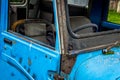 Abandoned vintage car blue lush green grass steering car interior