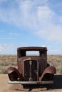 Abandoned vintage car sitting in the middle of a barren desert