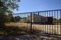 Abandoned warehouse behind a closed gate on a sunny day in the countryside Royalty Free Stock Photo