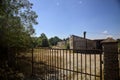 Abandoned warehouse behind a closed gate on a sunny day in the countryside Royalty Free Stock Photo