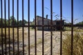 Abandoned warehouse behind a closed gate on a sunny day in the countryside Royalty Free Stock Photo