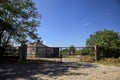 Abandoned warehouse behind a closed gate on a sunny day in the countryside Royalty Free Stock Photo