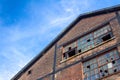Abandoned warehouse building, brick facade with broken windows, blue sky copy space Royalty Free Stock Photo
