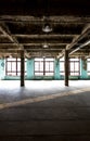 Abandoned warehouse at factory with long hallway and big windows Royalty Free Stock Photo