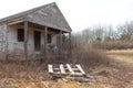 Abandoned old wooden farmhouse cabin overgrown with trees and vines Royalty Free Stock Photo