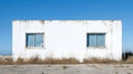 Abandoned White Building With Two Windows Against Clear Blue Sky Royalty Free Stock Photo