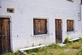 An abandoned white building with wooden doors and wooden shutters in the italian Alps Trentino, Italy Royalty Free Stock Photo