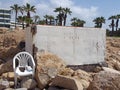 Abandoned white painted concrete bunker in paphos cyprus dating from the civil war era with broken white plastic chair and rock