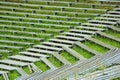 Abandoned wooden benches and bleachers in grass at old rural stadium Royalty Free Stock Photo