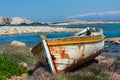 abandoned wooden fish boat at the shore. The boat is destroyed and rusty an completely useless with the sea and the blue sky at Royalty Free Stock Photo
