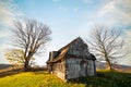 Abandoned wooden house surrounded by bare trees in highland Royalty Free Stock Photo