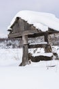 Abandoned wooden village well in deep snow