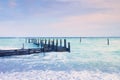 Abandoned wooden wharf in sea within sunrise.Gentle blue pink color of sky, blur waves Royalty Free Stock Photo