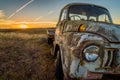 Abandoned wreck car in a field in Australia at sunset