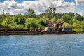 Abandoned wreck of old rusty boat half submerged in the river